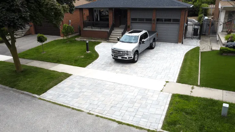 Neatly maintained property with a fresh interlock driveway and walkway at a suburban brick home